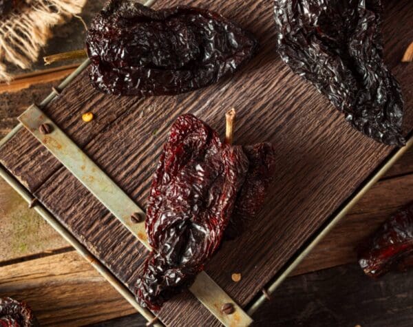 Dried chili peppers on a wooden surface.