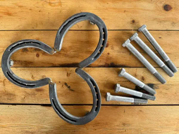 Horseshoe trivet with bolts on wood