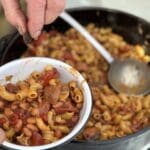 A bowl of baked beans and macaroni.