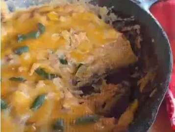 Cheesy casserole in a cast iron skillet.