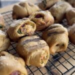 Grilled cheesy rolls on a wire rack.