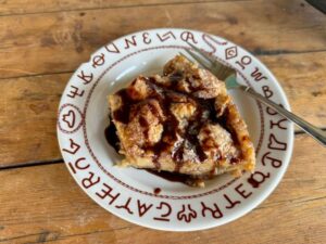 Cowboy Kent Rollins' Beer Bread Pudding on a plate filled with southwestern hieroglyphic symbols
