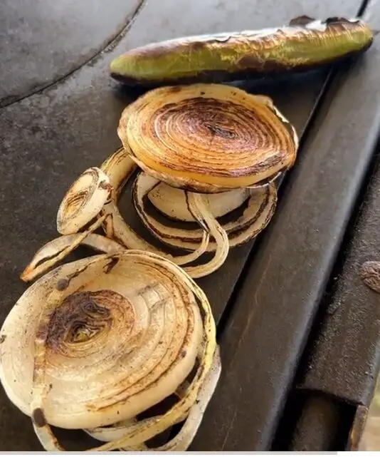 Grilled onion circles and a grilled serrano peppers, pushed over to the edge of the skillet on Kent's infamous grill, Bertha