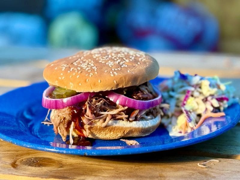 Cowboy Kent Rollins pulled pork on the smoker sandwich on a blue plate
