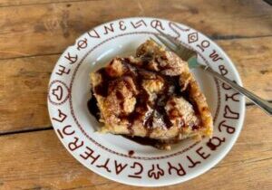 Cowboy Kent Rollins' Beer Bread Pudding on a plate filled with southwestern hieroglyphic symbols